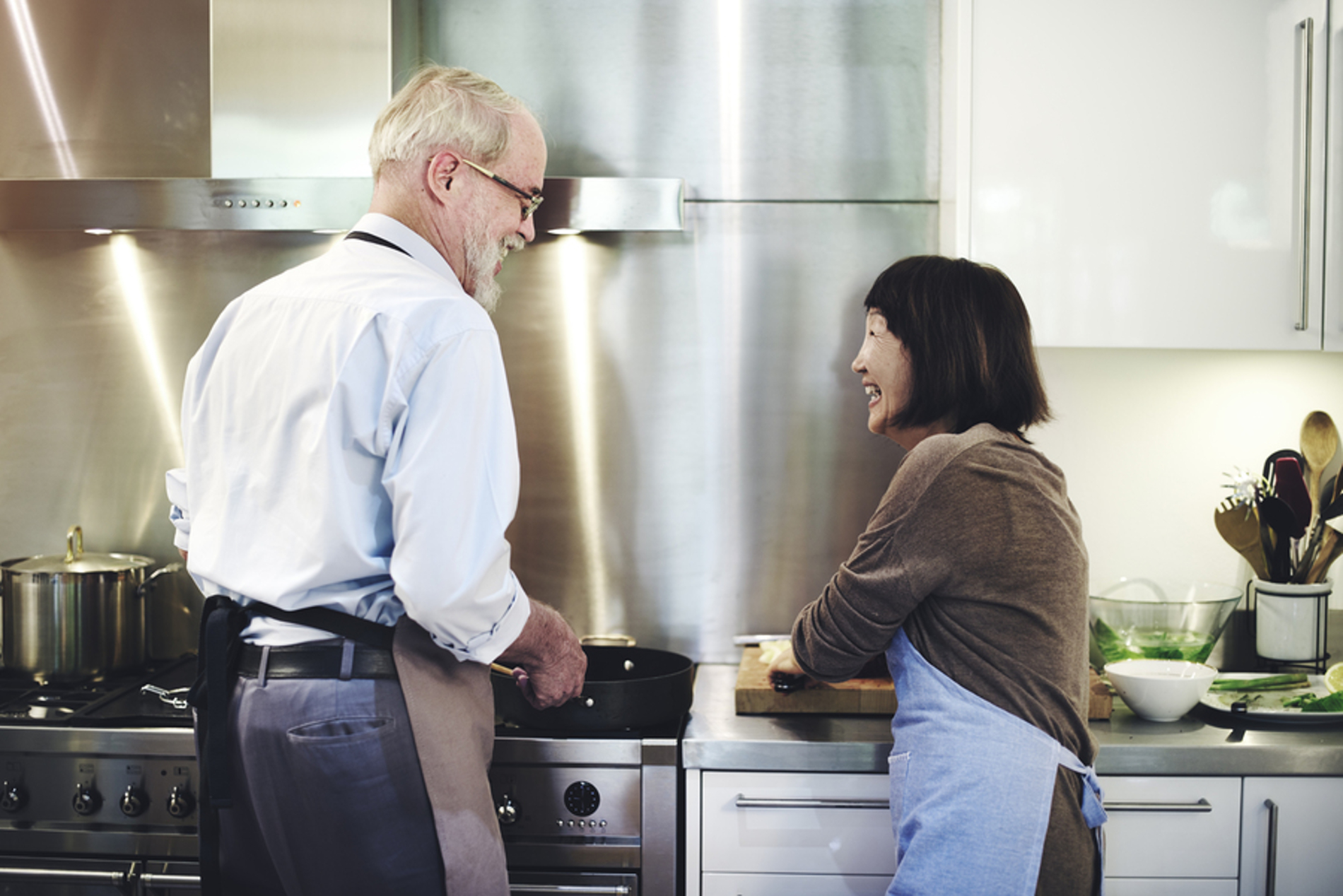 Two people cooking in a kitchen.